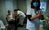 A nurse administers a Pfizer/Biontech COVID-19 vaccine to a health care worker in Liege, Belgium, January 27, 2021. (AP Photo/Francisco Seco)