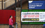 Signage gives COVID-19 safety advice on the fence a school in east London, January 3, 2021. (Daniel Leal-Olivas/AFP)