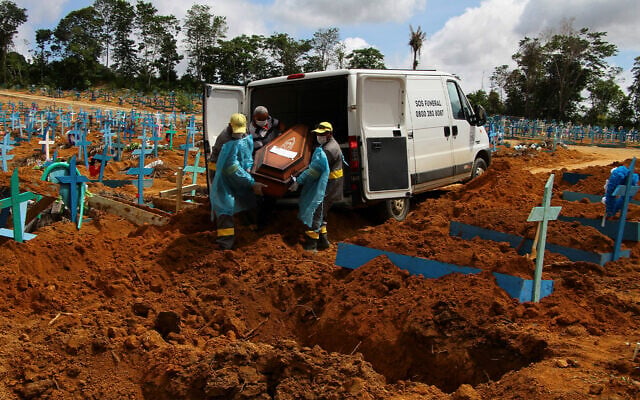 Cemetery workers carry the remains of a person who died of COVID-19 to bury in Manaus, Amazonas state, Brazil, Jan. 6, 2021. (AP Photo/Edmar Barros) Cemetery workers carry the remains of a person who died of COVID-19 to bury in Manaus, Amazonas state, Brazil, Jan. 6, 2021. (AP Photo/Edmar Barros)