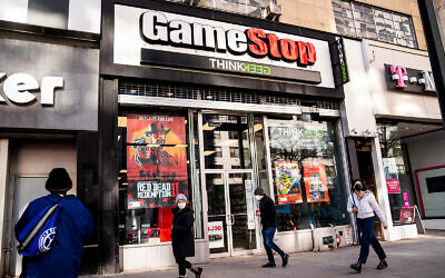 Pedestrians pass a GameStop store in New York City, January 28, 2021. (AP Photo/John Minchillo)