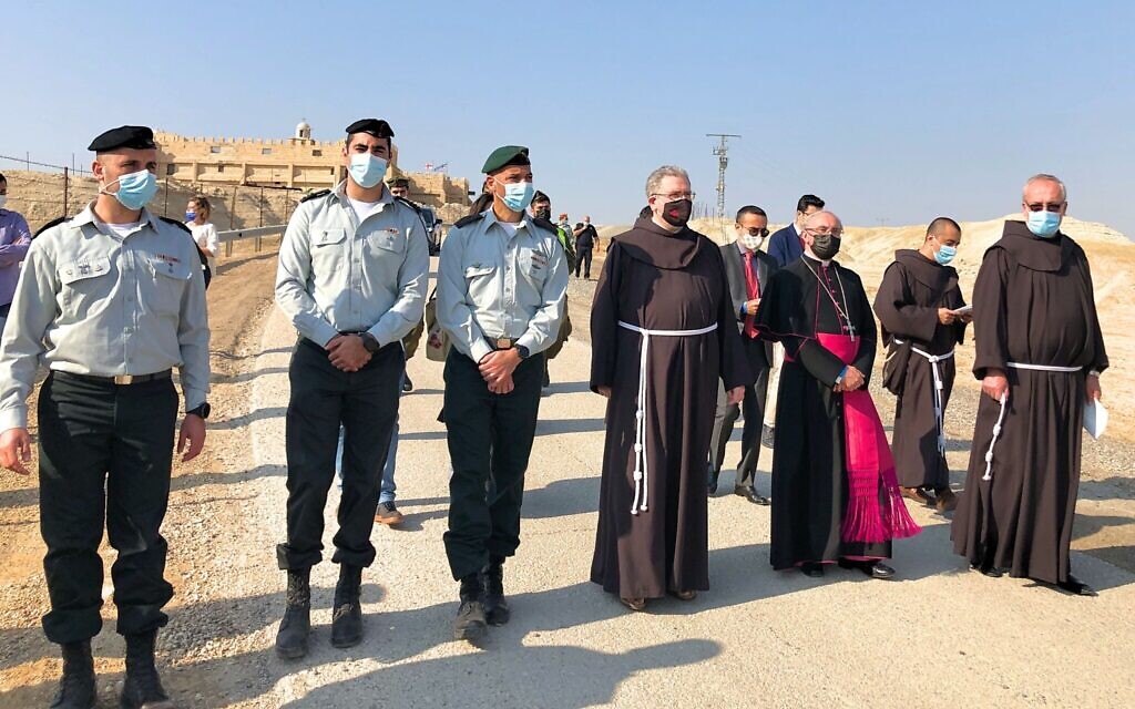IDF officers escort Father Francesco Patton, the Custos of the Holy Land (center) and Vatican Ambassador to Israel Archbishop Leopoldo Girelli (to his right) to the St John the Baptist Chapel to the banks of the Jordan River, January 10, 2021. (Amanda Borschel-Dan/Times of Israel)