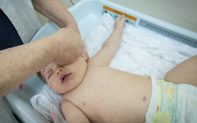 A baby seen on a weight scale, as part of a medical exam, at a family health center in Israel on March 5, 2019. (Chen Leopold/Flash90) A baby seen on a weight scale, as part of a medical exam, at a family health center in Israel on March 5, 2019. (Chen Leopold/Flash90)