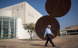 A man wears a protective face mask as he walks by the closed Habima Theater in Tel Aviv, on October 20, 2020. (Miriam Alster/ FLASH90)