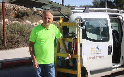 A Tenufa Bakehila volunteer with the organization's emergency repair vehicle, used to do home repairs for free for those in need during the coronavirus (Courtesy Mark Neyman/GPO)
