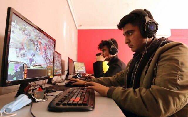 Young Iranians play an online multiplayer game at an internet cafe in Iran's capital Tehran on January 24, 2021. (Atta Kenare/AFP) Young Iranians play an online multiplayer game at an internet cafe in Iran's capital Tehran on January 24, 2021. (Atta Kenare/AFP)
