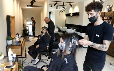 Women get their hair styled at a salon in Tel Aviv on February 7, 2021, following the lifting of a nationwide lockdown due to the COVID-19 pandemic. (JACK GUEZ / AFP)