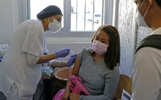 A foreign resident living in Israel receives a dose of COVID-19 coronavirus vaccine at the Tel Aviv Sourasky Medical Centre for foreign nationals in Tel Aviv on February 9, 2021 during a campaign to vaccinate foreign workers and refugees against coronavirus. (JACK GUEZ / AFP)