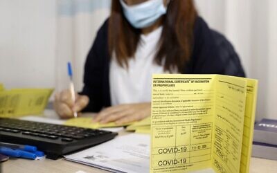 In this file photo taken on December 19, 2020 an Israeli medical worker fills an international certificate of vaccination for coronavirus at the Sheba Medical Center, the country's largest hospital, in Ramat Gan near the coastal city of Tel Aviv. (JACK GUEZ / AFP)