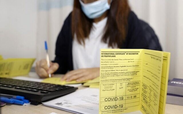 In this file photo taken on December 19, 2020 an Israeli medical worker fills an international certificate of vaccination for coronavirus at the Sheba Medical Center, the country's largest hospital, in Ramat Gan near the coastal city of Tel Aviv. (JACK GUEZ / AFP)