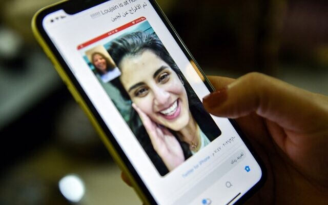 This picture taken on February 10, 2021 in Saudi Arabia's capital Riyadh shows a woman viewing a tweet posted by the sister of Saudi activist Loujain al-Hathloul, Lina, showing a screenshot of them having a video call following Hathloul's release after nearly three years in detention (Fayez Nureldine / AFP) This picture taken on February 10, 2021 in Saudi Arabia's capital Riyadh shows a woman viewing a tweet posted by the sister of Saudi activist Loujain al-Hathloul, Lina, showing a screenshot of them having a video call following Hathloul's release after nearly three years in detention (Fayez Nureldine / AFP)