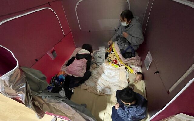 An evacuated family rests at a shelter set up in a sports arena in Soma, Fukushima prefecture on February 14, 2021, after a 7.3-magnitude earthquake struck off Japan's east coast late on February 13. (STR / JIJI PRESS / AFP) / Japan OUT An evacuated family rests at a shelter set up in a sports arena in Soma, Fukushima prefecture on February 14, 2021, after a 7.3-magnitude earthquake struck off Japan's east coast late on February 13. (STR / JIJI PRESS / AFP) / Japan OUT