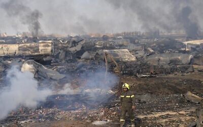A firefighter walks amidst wreckage of gas tankers after a fire accident at Islam Qala on the outskirts of Herat, in the border between Afghanistan and Iran on February 14, 2021. (HOSHANG HASHIMI / AFP)