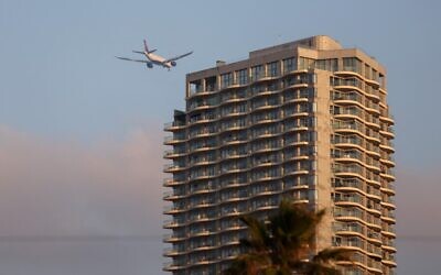 A plane flies above an apartment building in Tel Aviv. (Emmanuel Dunand/AFP)