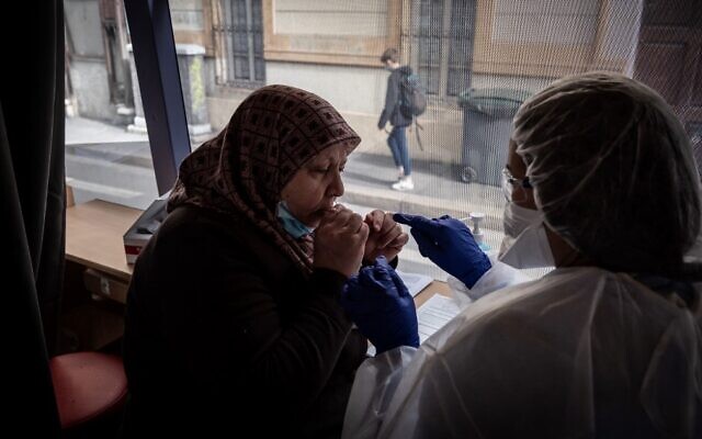 A patient (L) is watched by a medical assistant as she spits into a test tube for a COVID-19 saliva test on a roving bus in Saint-Etienne, France, on February 22, 2021. (Jean-Philippe Ksiazek/AFP) A patient (L) is watched by a medical assistant as she spits into a test tube for a COVID-19 saliva test on a roving bus in Saint-Etienne, France, on February 22, 2021. (Jean-Philippe Ksiazek/AFP)