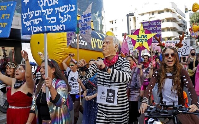 Israelis wearing costumes take part in a parade during the festivities of the Jewish holiday of Purim, while also protesting against Prime Minister Benjamin Netanyahu, on February 26, 2021 in Tel Aviv (JACK GUEZ / AFP) Israelis wearing costumes take part in a parade during the festivities of the Jewish holiday of Purim, while also protesting against Prime Minister Benjamin Netanyahu, on February 26, 2021 in Tel Aviv (JACK GUEZ / AFP)
