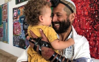 Alander Especie, shown with his daughter Liz, puts on tefillin every day. (Courtesy of Especie/ via JTA)