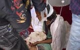 An elderly woman who fled to the city of Axum in the Tigray region of Ethiopia to seek safety sits with her head bandaged after being wounded during an attack on the city, November 30, 2020. (AP Photo)