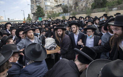 Ultra-Orthodox Jews carry the body of Rabbi Meshulam Soloveitchik during his funeral in Jerusalem, Sunday, Jan. 31, 2021. The mass ceremony took place despite the country's health regulations banning large public gatherings, during a nationwide lockdown to curb the spread of the virus. (AP Photo/Ariel Schalit)