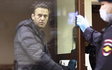 In this image made from video provided by the Babuskinsky District Court, Russian opposition leader Alexei Navalny stands in a cage during a hearing on his charges for defamation,  in the Babuskinsky District Court in Moscow, Russia, Friday, February 5, 2021.  (Babuskinsky District Court via AP)
