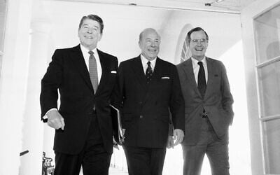 Then-secretary of state George Shultz, center, walks with then-president Ronald Reagan and vice president George Bush upon his arrival at the White House in Washington, after two days of arms talks with the Soviet Union in Geneva, on January 9, 1985. (AP Photo/Barry Thumma, File)