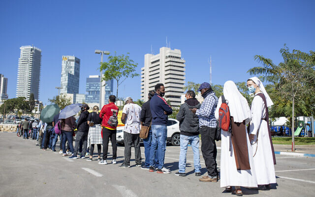 Nuns, asylum seekers and foreign workers wait in line to receive their first dose of the Pfizer-BioNTech coronavirus vaccine at a vaccination center in Tel Aviv, Israel, Tuesday, Feb. 9, 2021 (AP Photo/Ariel Schalit) Nuns, asylum seekers and foreign workers wait in line to receive their first dose of the Pfizer-BioNTech coronavirus vaccine at a vaccination center in Tel Aviv, Israel, Tuesday, Feb. 9, 2021 (AP Photo/Ariel Schalit)