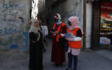 Members of Gaza's Central Elections Commission's field team register a local woman to the electoral roll, at the main road of Gaza City, February 10, 2021 (AP Photo/Adel Hana)