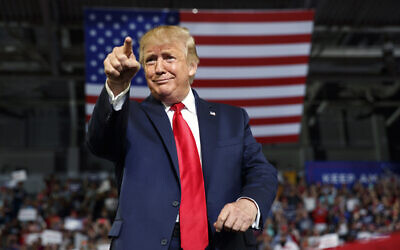Then-US president Donald Trump gestures to the crowd as he arrives to speak at a campaign rally at Williams Arena in Greenville, North Carolina, July 17, 2019. (AP Photo/Carolyn Kaster, File)