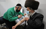 Rabbi Bieberfeld is administered a dose of the AstraZeneca coronavirus vaccine at an event to encourage vaccine uptake in Britain's Haredi Orthodox Jewish community at the John Scott Vaccination Centre in London, February 13, 2021. (AP Photo/Frank Augstein)