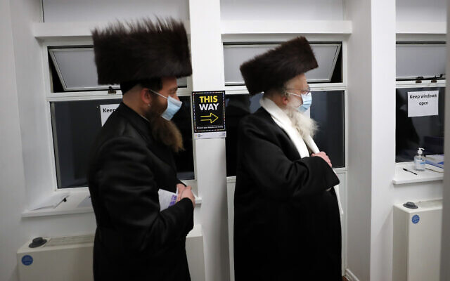 Two men from the Haredi Orthodox Jewish community arrive at an event to encourage vaccine uptake in Britain's Haredi community at the John Scott Vaccination Centre in London, Saturday, Feb. 13, 2021 (AP Photo/Frank Augstein)
