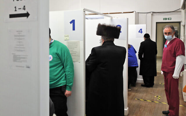 Members of the Haredi Orthodox Jewish community receive AstraZeneca vaccinations at an event to encourage vaccine uptake in Britain's Haredi community at the John Scott Vaccination Centre in London, Saturday, Feb. 13, 2021 (AP Photo/Frank Augstein)
