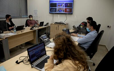People work at a digital task force to counter "fake news" on the internet, in the Health Ministry office near Tel Aviv, February 14, 2021. (AP Photo/Ariel Schalit)
