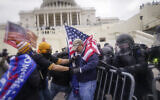 Rioters try to break through a police barrier at the Capitol in Washington, January 6, 2021. (AP Photo/John Minchillo, File)