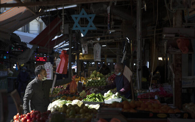 Israelis shop at a market in Tel Aviv, Israel, Sunday, Feb. 21, 2021. Israel lifted many of its coronavirus restrictions and started reopening its economy Sunday as the country's vaccination drive and third nationwide lockdown have started to bring down infections. (AP Photo/Sebastian Scheiner) Israelis shop at a market in Tel Aviv, Israel, Sunday, Feb. 21, 2021. Israel lifted many of its coronavirus restrictions and started reopening its economy Sunday as the country's vaccination drive and third nationwide lockdown have started to bring down infections. (AP Photo/Sebastian Scheiner)