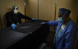 In this Jan. 9, 2021, file photo, transporters Miguel Lopez, right, Noe Meza move a body of a COVID-19 patient to a morgue at Providence Holy Cross Medical Center in the Mission Hills section of Los Angeles.(AP Photo/Jae C. Hong, File)