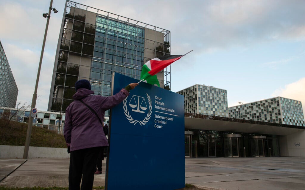 A demonstrator poses with a Palestinian flag outside the International Criminal Court, ICC, during a rally urging the court to prosecute Israel's army for war crimes, in The Hague, Netherlands, November 29, 2019. (AP/Peter Dejong) A demonstrator poses with a Palestinian flag outside the International Criminal Court, ICC, during a rally urging the court to prosecute Israel's army for war crimes, in The Hague, Netherlands, November 29, 2019. (AP/Peter Dejong)