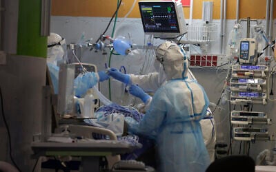 Medical professionals in full protective equipment tend to an elderly man on a ventilator in the critical care coronavirus unit at Sheba Medical center in Ramat Gan, Wednesday, Sept. 30, 2020 (AP Photo/Maya Alleruzzo)