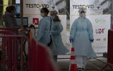 Health care workers wait to administer nose-swab tests at the mobile COVID-19 testing site in Antwerp, Belgium, Oct. 20, 2020 (AP Photo/Virginia Mayo)