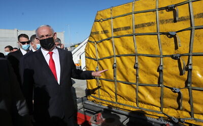 Prime Minister Benjamin Netanyahu attends the arrival of over 100,000 doses of the Pfizer coronavirus vaccine, at Ben Gurion Airport, on December 9, 2020. (Abir Sultan/Pool Photo via AP)