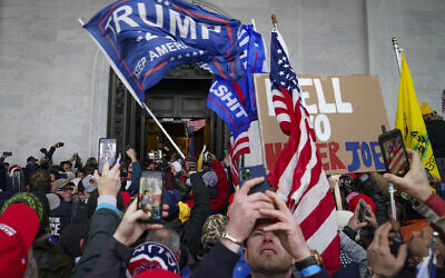 In this January 6, 2021, photo, Trump supporters gather outside the Capitol in Washington. (AP Photo/John Minchillo)