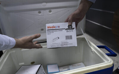 Illustrative: Palestinian medics unpack Moderna COVID-19 vaccines and supplies that are designated for front-line medical workers, at the health ministry, in the West Bank city of Bethlehem, February 3, 2021. The Palestinian Authority has administered its first known coronavirus vaccinations after receiving several thousands of doses of the Moderna vaccine from Israel. (AP Photo/Nasser Nasser)