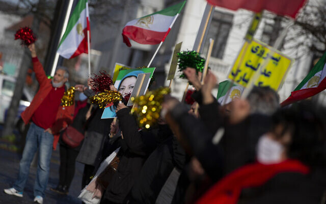 People wave flags after the trial of four persons, including an Iranian diplomate and Belgian-Iranian couple at the courthouse in Antwerp, Belgium, February 4, 2021. (AP Photo/Virginia Mayo) People wave flags after the trial of four persons, including an Iranian diplomate and Belgian-Iranian couple at the courthouse in Antwerp, Belgium, February 4, 2021. (AP Photo/Virginia Mayo)