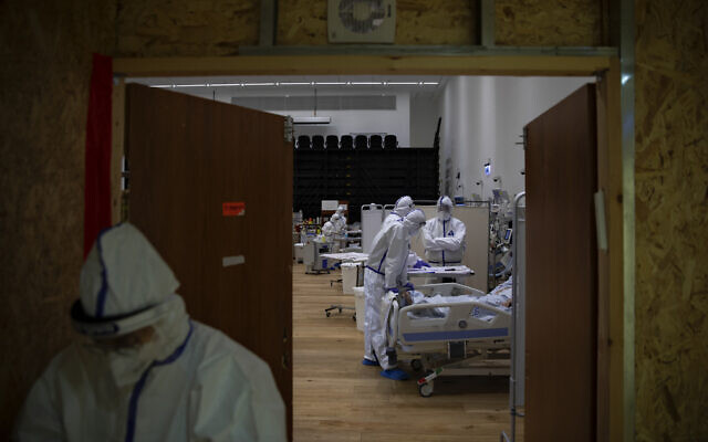 Medical personnel wearing protective equipment treat COVID-19 patients in an intensive care ward for coronavirus patients at Ziv Medical Center in the northern Israeli city of Safed, Feb. 7, 2021. (AP Photo/Oded Balilty)