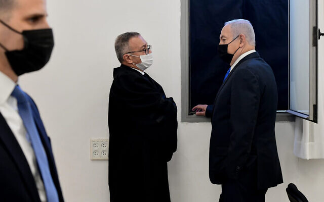 Prime Minister Benjamin Netanyahu, right, speaks with his lawyers prior to a hearing at the district court in Jerusalem, February 8, 2021. (Reuven Castro/AP) Prime Minister Benjamin Netanyahu, right, speaks with his lawyers prior to a hearing at the district court in Jerusalem, February 8, 2021. (Reuven Castro/AP)