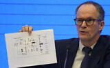Peter Ben Embarek of the World Health Organization team holds up a chart showing pathways of transmission of the virus during a joint press conference held at the end of the WHO mission in Wuhan in central China's Hubei province on Feb. 9, 2021. (AP Photo/Ng Han Guan)