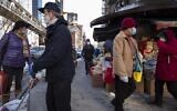 Shoppers walk with their purchases, Monday, Feb. 8, 2021, in the Chinatown neighborhood of New York. (AP Photo/Mark Lennihan)