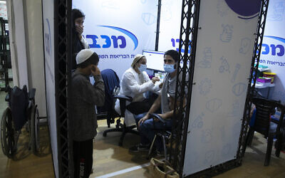 A man receives a Pfizer-BioNTech COVID-19 vaccine during an event to encourage the vaccination of young Israelis at a vaccination center in Holon, Feb. 15, 2021. (AP Photo/Sebastian Scheiner)