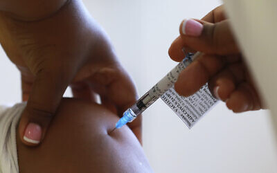 A health care worker receives a Johnson & Johnson vaccine at a hospital in Khayelitsha, Cape Town, South Africa, February 17, 2021. (AP Photo/Nardus Engelbrecht)