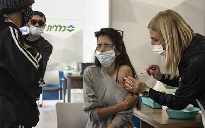 An Israeli woman receives a Pfizer-BioNTech COVID-19 vaccine at a Clalit medical center in Dimona, Southern Israel, Sunday, Feb. 21, 2021. (AP Photo/Tsafrir Abayov)