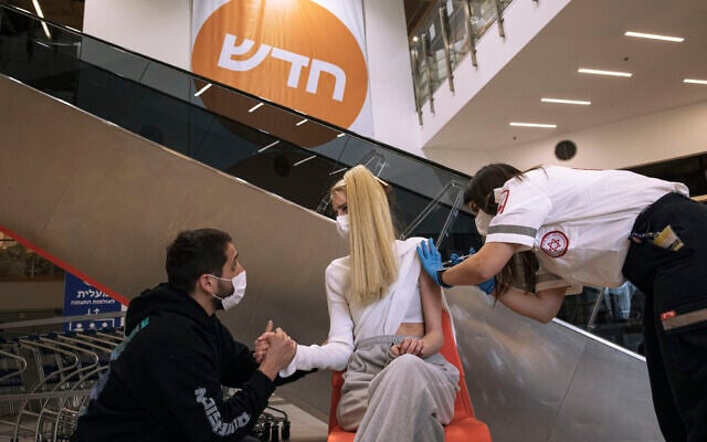A paramedic from Magen David Adom medical services, administers a dose of the Pfizer-BioNtech COVID-19 vaccine to a woman at an Ikea store in Rishon Lezion, Israel, Feb. 22, 2021 (AP Photo/Tsafrir Abayov) A paramedic from Magen David Adom medical services, administers a dose of the Pfizer-BioNtech COVID-19 vaccine to a woman at an Ikea store in Rishon Lezion, Israel, Feb. 22, 2021 (AP Photo/Tsafrir Abayov)