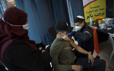 Israeli medical teams administer the coronavirus vaccine to Palestinians at the Qalandia checkpoint on Feb. 23, 2021 (AP Photo/Oded Balilty)